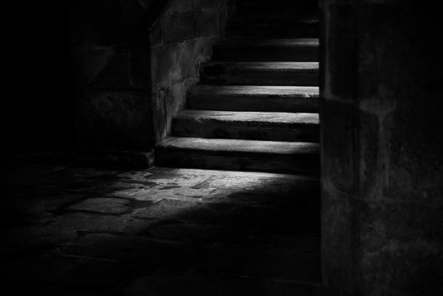 Low key photo of light highlighting steps leading down to basement