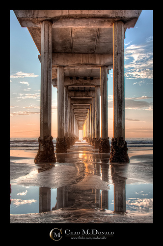 Under the Pier - landscape photo of a view under a pier at sunset, with the lines of the pier creating converging lines