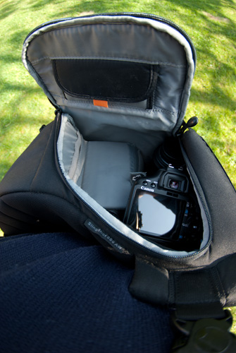 Sling bag slung round to the front with side open for easy access of camera and lenses