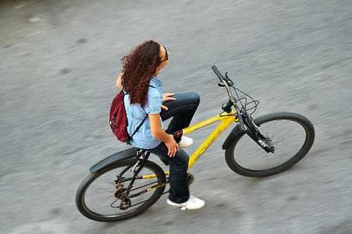 High angle panning shot of woman riding a bike