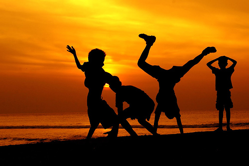 Silhouettes of children playing at sunset