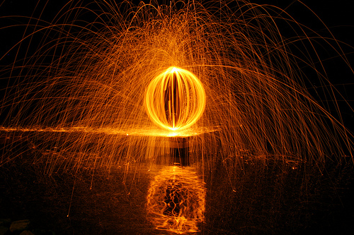 Lava Orb Below - burning steel wool spun in an orb pattern, with a reflection in the water below