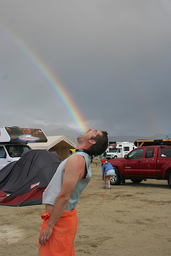 Trick forced perspective photo of a man eating a rainbow