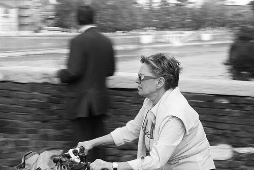 Street photo of a woman on a bike, taken using a 50mm lens