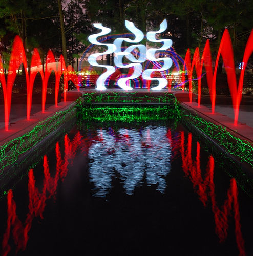 Elaborate large light painting around a pond incorporating a variety of lights