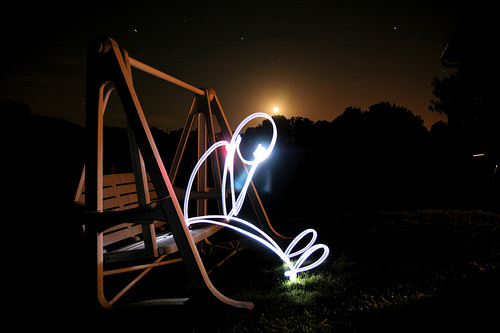 Light painting of a person sitting on a swing seat