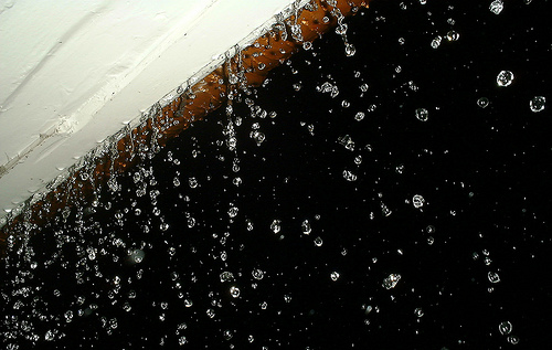 Rain pouring off the roof at night, frozen with use of flash