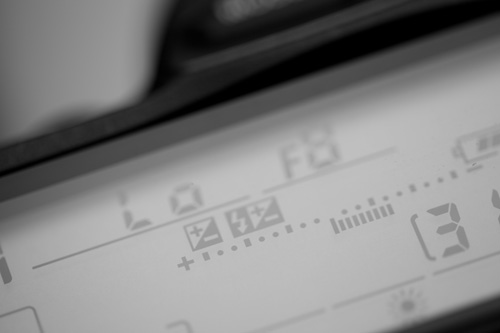 Top LCD of a Nikon camera showing the exposure meter with -1.3EV of exposure compensation applied