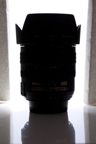 Photo of camera lens with background lit and polystyrene sheets used near product to minimize light spill from the background.