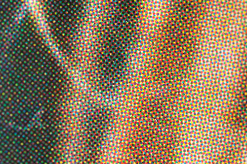 Extreme close-up of a magazine cover showing the dots of cyan, magenta, yellow, and black ink (cmyk)
