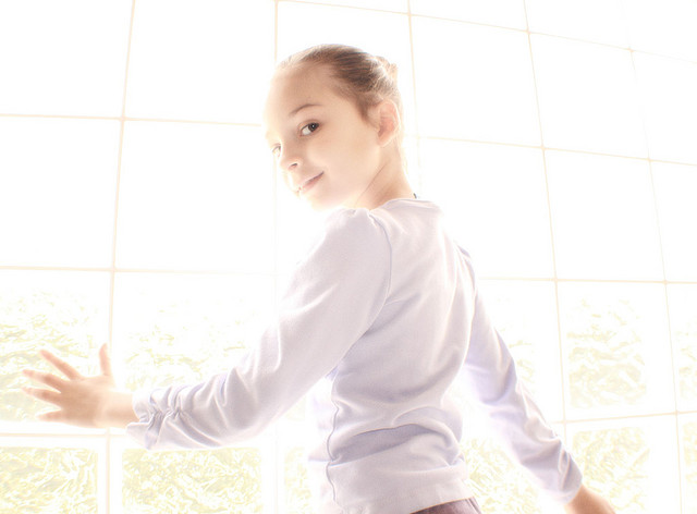 Portrait of a girl posing in front of a window, shot in manual exposure mode with exposure set to create a high key image