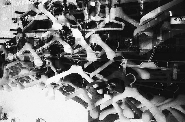 Black and white film photograph of coat hangers and reflections - photographed using a fixed focal length 35mm lens