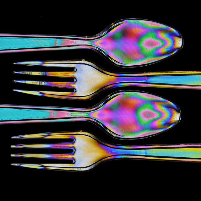 Cross polarized photo of plastic cutlery showing stress patterns in the plastic as colorful bands