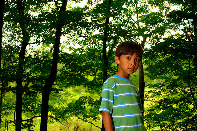 Portrait taken in woodland with the subject's back to the sun, and their front lit with flash