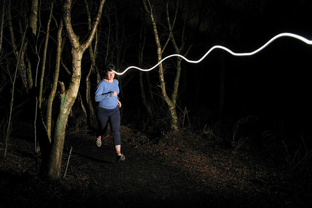 Front / First curtain flash sync example - runner frozen with light trail from their headlamp extending in front of them