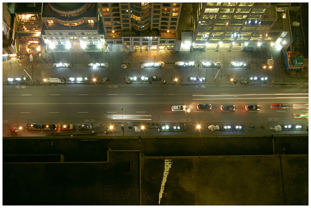 Looking down at the street below from a rooftop at night