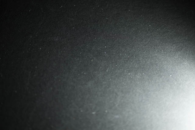 Piece of black card lit by speedlight flash fired at minimum power (1/128)