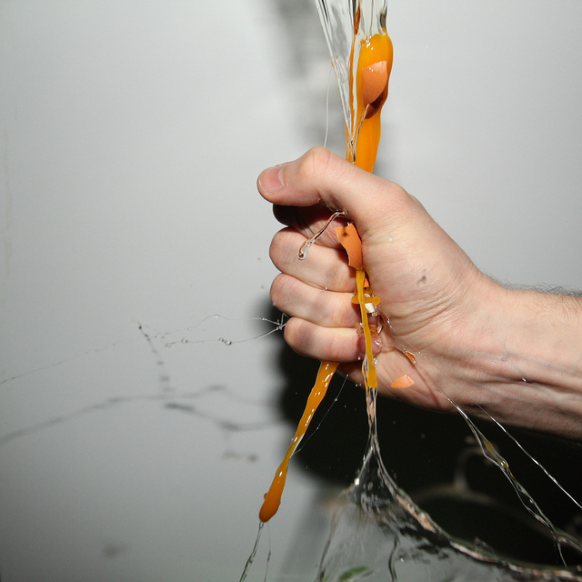 High speed photo of an egg being smashed by squeezing it in the hand