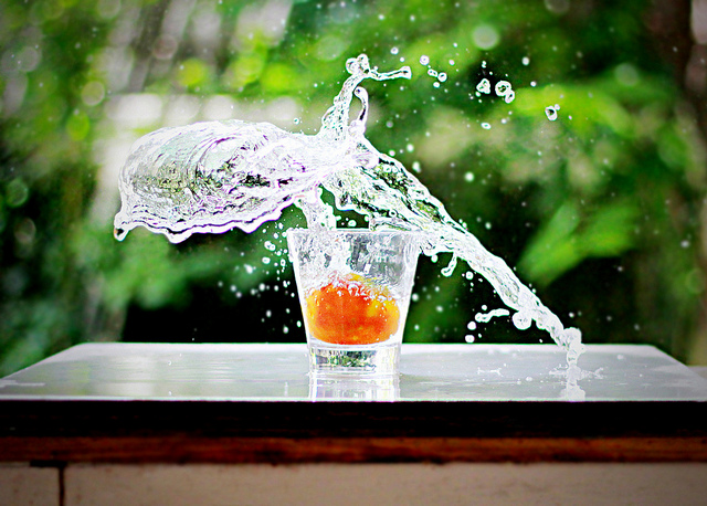 High speed photo of the splash caused by dropping a piece of fruit into a glass of water. A combination of high ISO and large aperture was used to get a good exposure at such a fast shutter speed