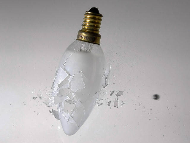 A light bulb smashing as a ball bearing pellet is fired through it