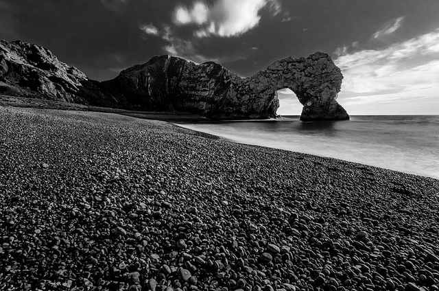 Long exposure of Durdle Door in Weymouth using Welding Glass as a low cost ND filter. The welding glass gives a strong color cast, but the image has been converted to black and white, so no color cast is visible.