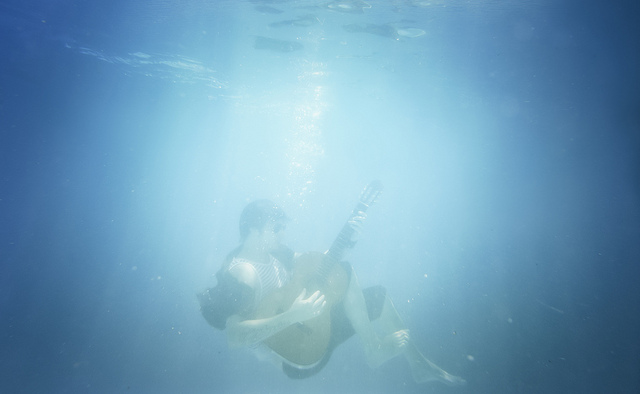 Man playing guitar underwater