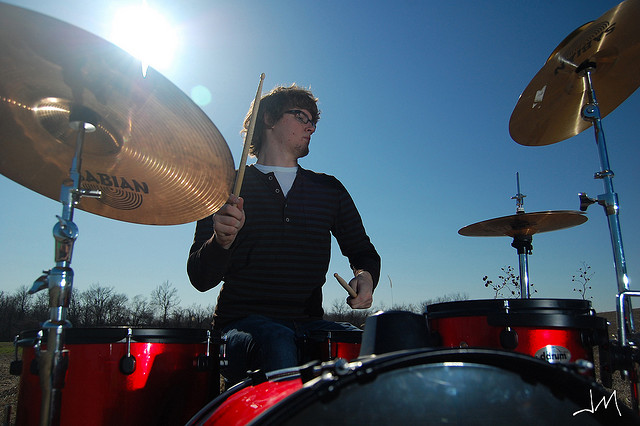 Drummer outdoors in sunshine, underexposed for the ambient light and lit with high speed sync flash